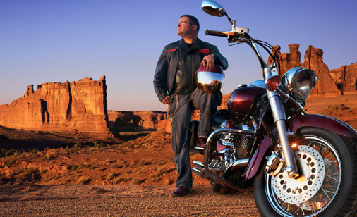 Man standing near a motorcycle in the desert