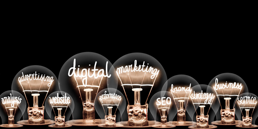 Photo of light bulbs with shining fibers in a shape of Digital Marketing, Website, SEO and Strategy concept related words isolated on black background.